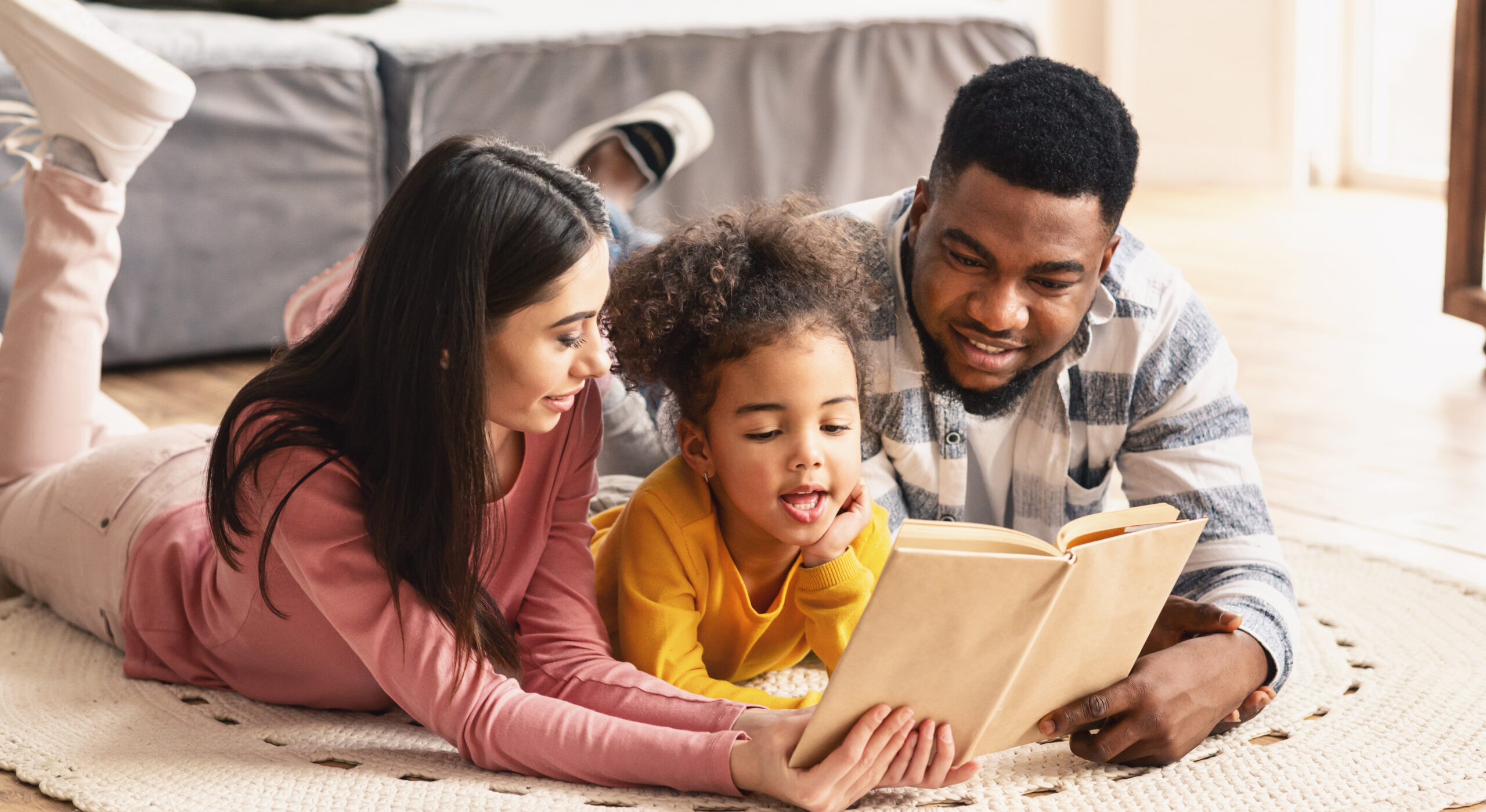 mother daughter father reading a book